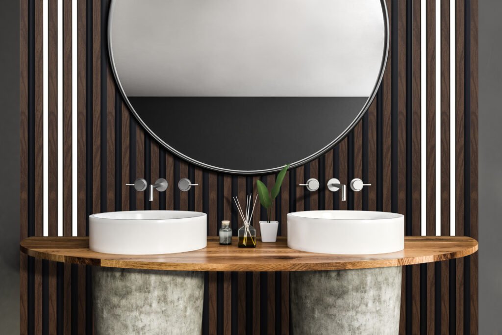 Close up of white and stone double bathroom sink standing on wooden shelf in room with gray walls and large round mirror. 3d rendering