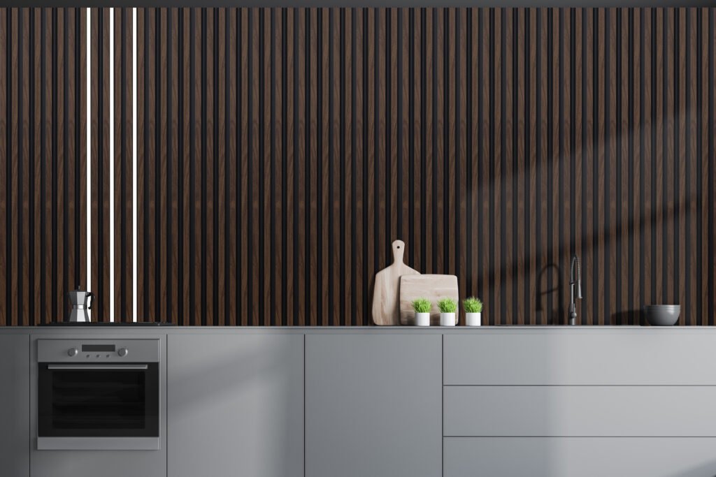 Interior of stylish kitchen with gray walls, grey countertops with built in sink and oven and wooden cutting boards with plants near them. 3d rendering