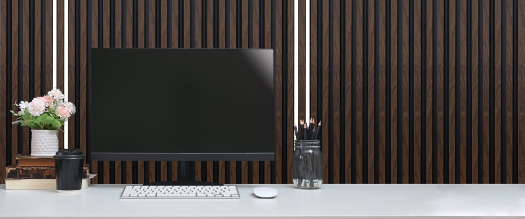 Computer and various equipment are putting on a white working desk in the comfortable living room.